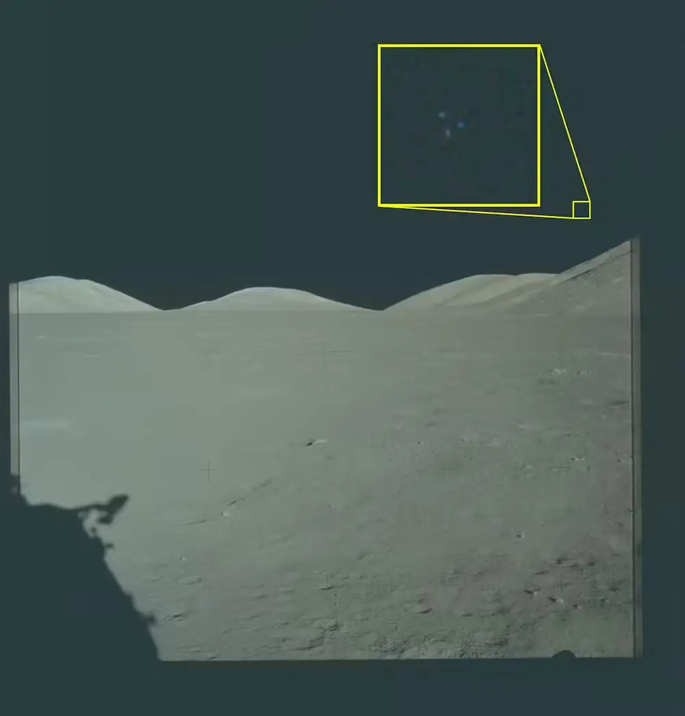 Lunar landscape with a distant horizon, featuring a bright yellow square around a region in the upper-right, as if highlighting a target area in a camera feed.